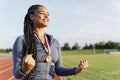 Portrait of female athlete celebrating with medal