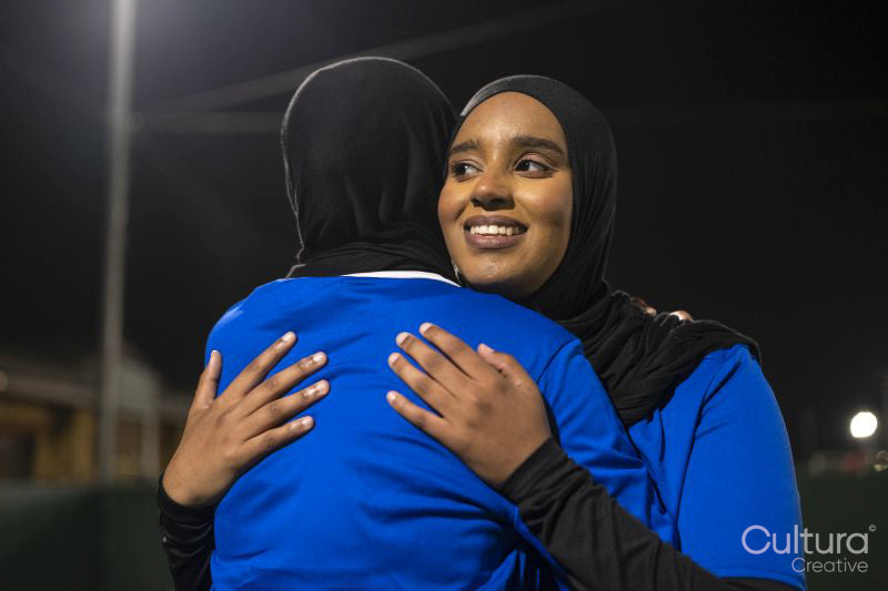 Female soccer players hugging