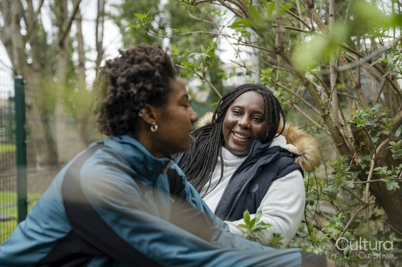 Mother and daughter talking during walk in park