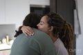 Two women embracing at home