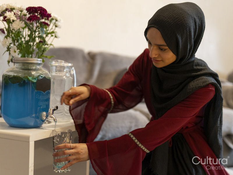 Woman pouring drink at home