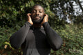 Portrait of athletic man with earbuds standing in park