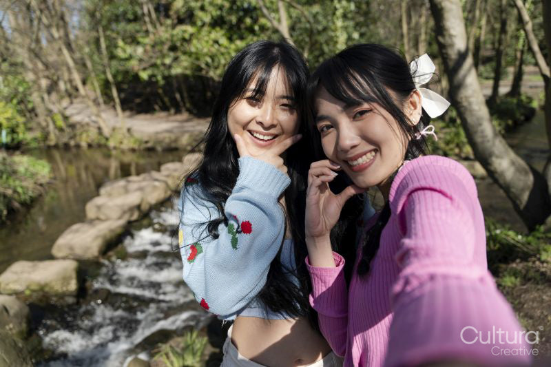 Young female friends taking selfie in park