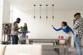 Friends playing beer pong at home party