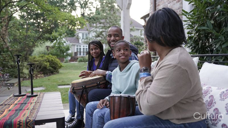 Family with children playing drums on patio