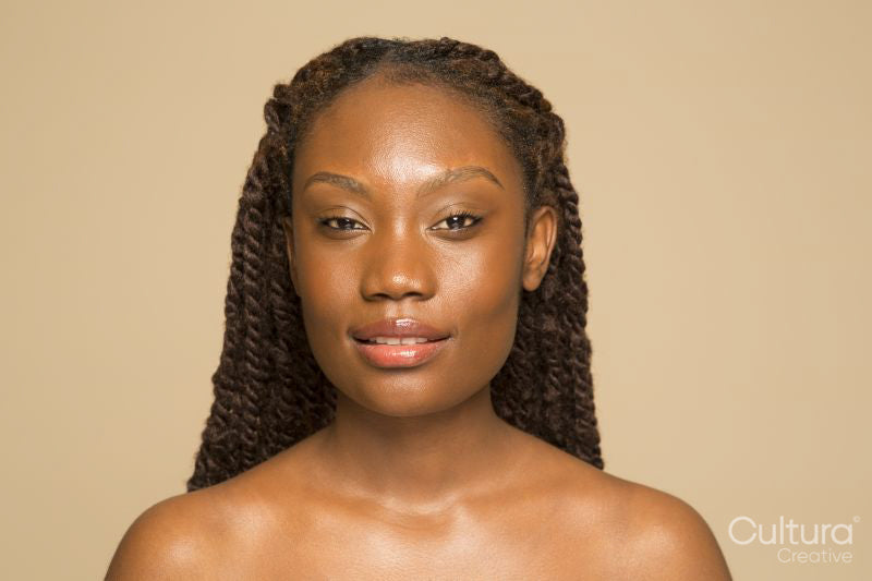 Studio portrait of smiling woman with braided hair