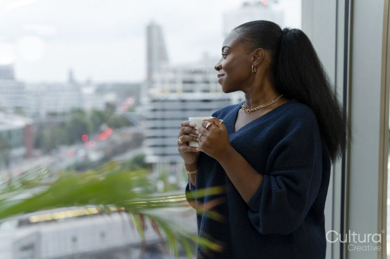 Thoughtful woman looking through window