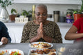 Family praying before eating dinner