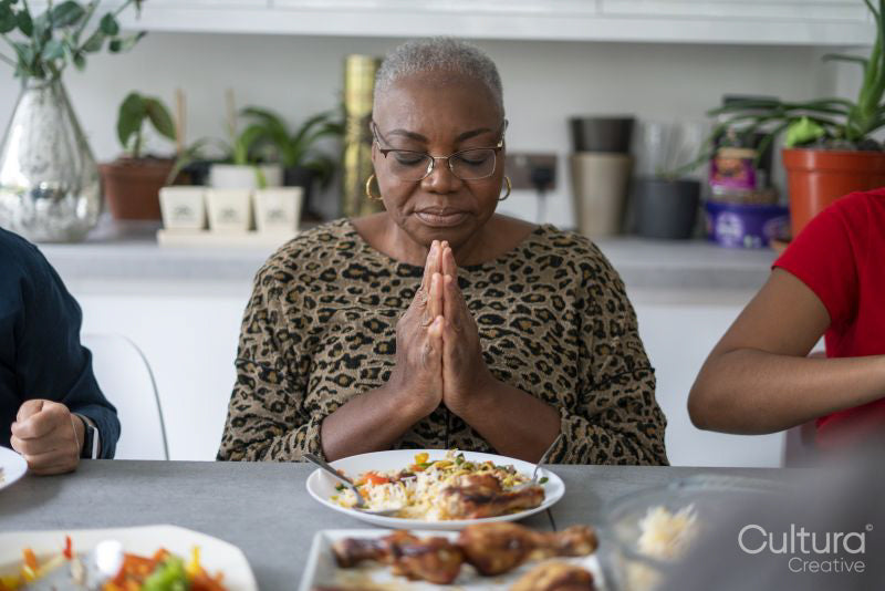 Family praying before eating dinner