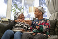 Senior couple sitting on sofa eating Christmas cookies