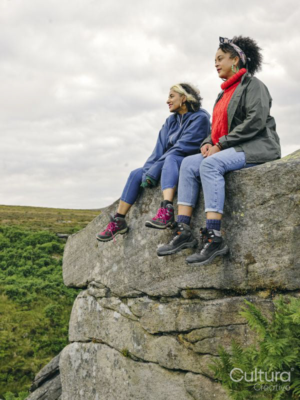 Female hikers sitting on rocks and looking at landscape