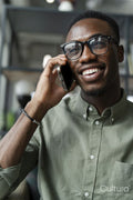 Young man with smartphone sitting in office lounge