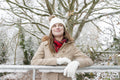 Portrait of smiling woman leaning on frozen railing