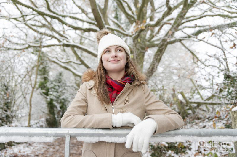 Portrait of smiling woman leaning on frozen railing