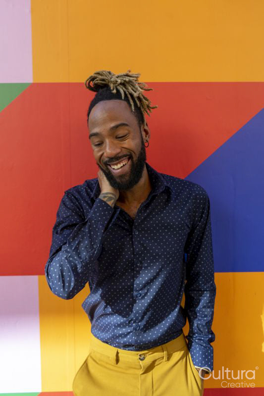 Smiling businessman standing against colorful wall