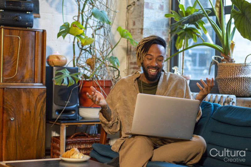 Man sitting on sofa and using laptop