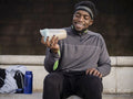 Athletic man preparing protein drink on steps outdoors