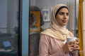 Portrait of smiling woman wearing headscarf holding cup