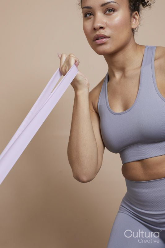 Studio portrait of athletic woman exercising with resistance band