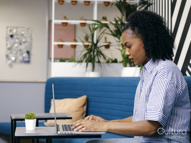 Woman using laptop in office lounge area