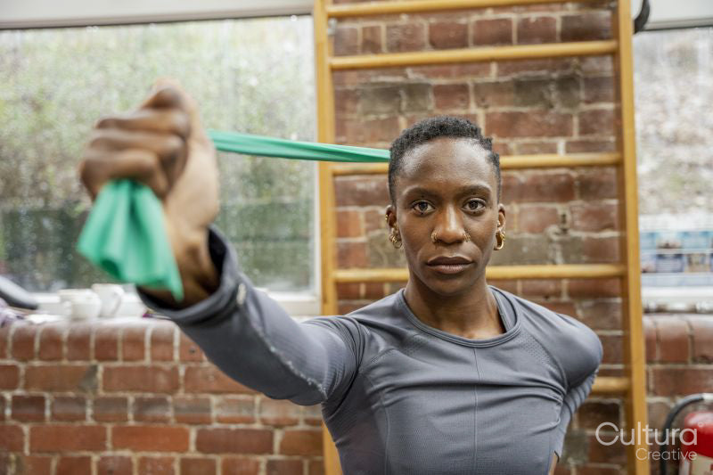 Athletic woman exercising with resistance band at gym