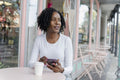Woman using smart phone during coffee break in sidewalk cafe