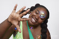 Studio shot of smiling young woman playing with soap bubbles