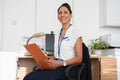 Smiling female doctor sitting at desk in office