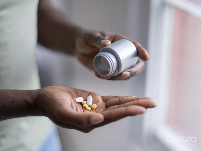 Close-up of person pouring pills on hand