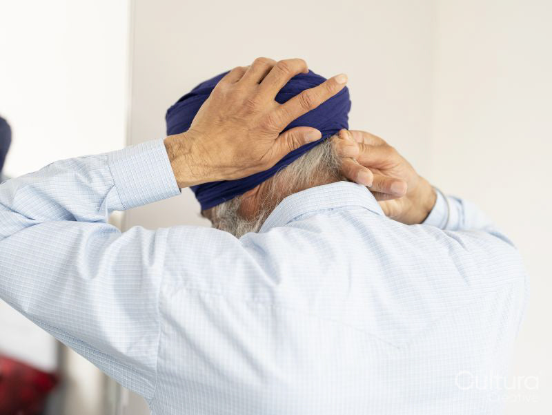 Senior man wrapping turban around head