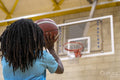 Teenage girl shooting ball on basketball court