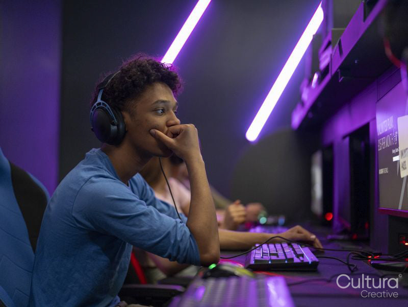 Young man playing video games in gaming club