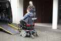 Father and disabled son using wheelchair lift