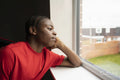 Teenage boy looking through window at home