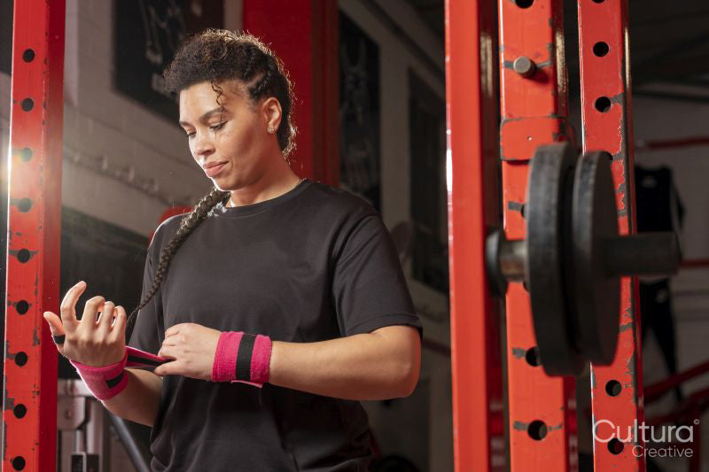 Woman bandaging her wrists before weightlifting training