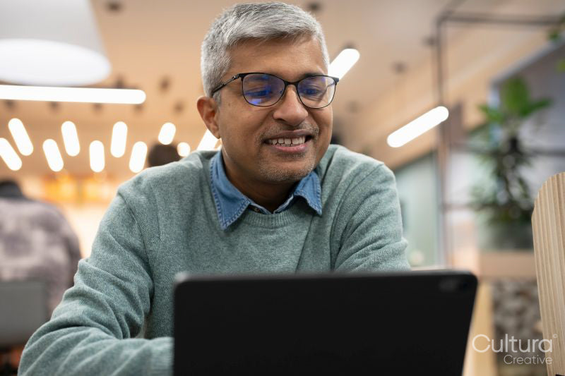Smiling mature businessman working on tablet in office