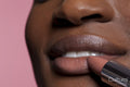 Young woman applying lipstick