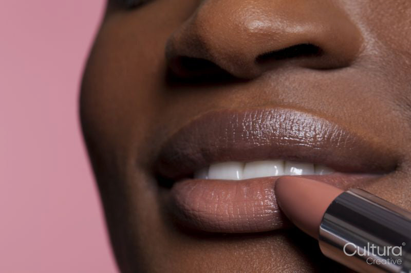 Young woman applying lipstick