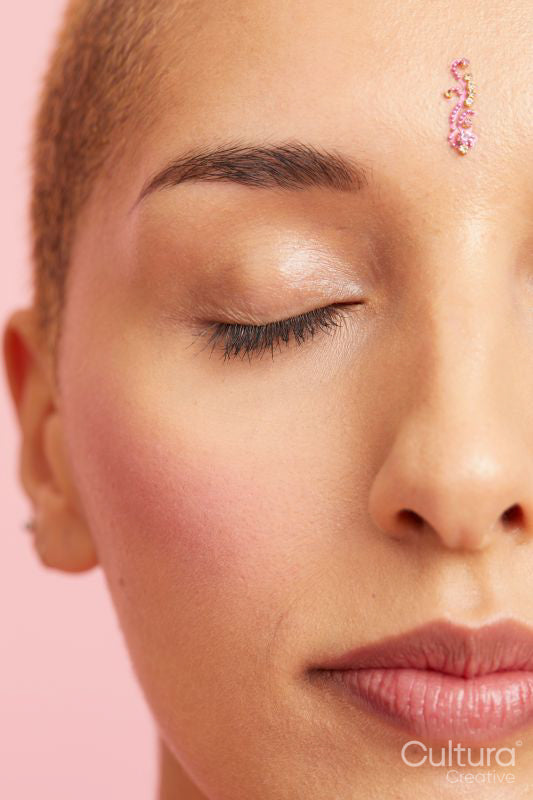 Close up of young woman with decoration on forehead, eyes closed