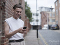 Smiling man using smart phone in city
