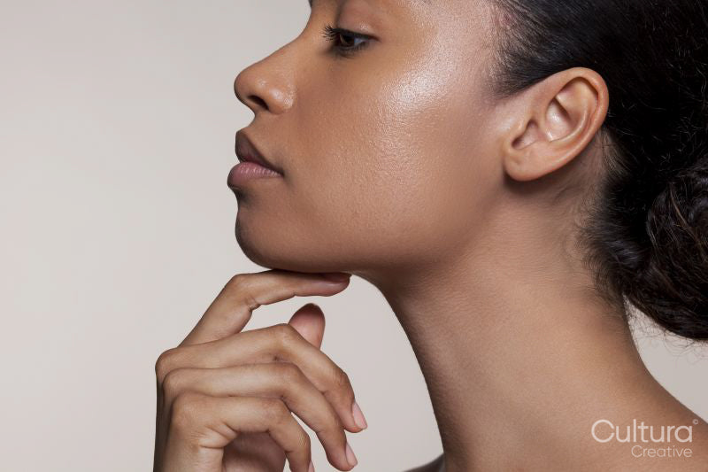 Side view of young woman touching chin
