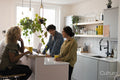 Creative professionals working on laptops in office kitchen