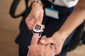 Close-up of female doctor using oximeter on senior patients finger in office