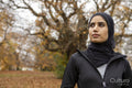 Portrait of woman in black sports clothing and hijab in park