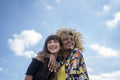 Female couple embracing against blue sky