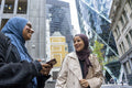 Two women wearing hijabs standing in street