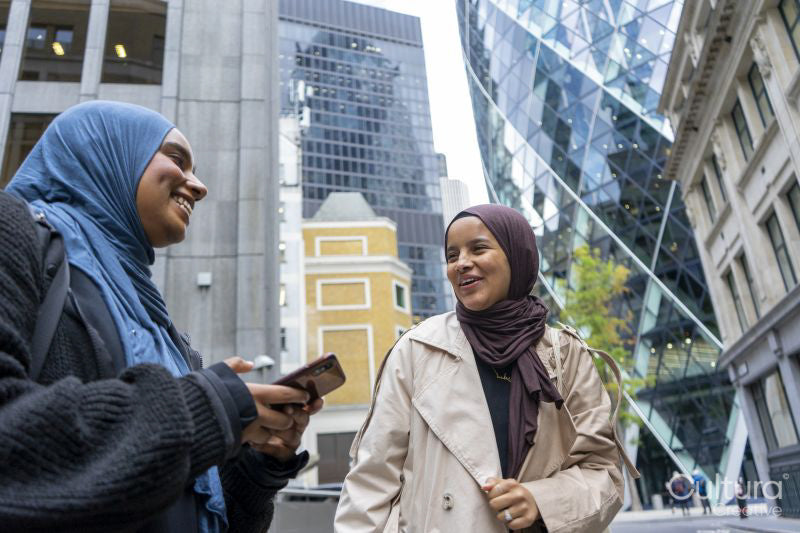 Two women wearing hijabs standing in street