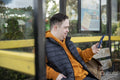 Man sitting on bench at bus stop, using smart phone