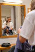 Smiling senior woman getting hair dried in hair salon