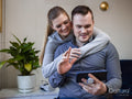 Smiling couple having video call via smart phone at home